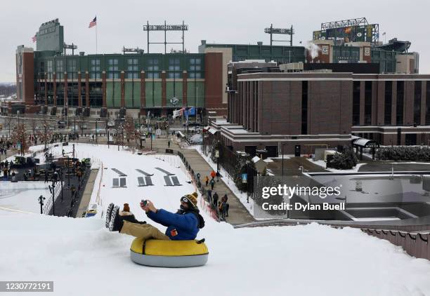 Green Bay Packers fan sleds on a tube outside the stadium prior to their NFC Championship game against the Tampa Bay Buccaneers at Lambeau Field on...