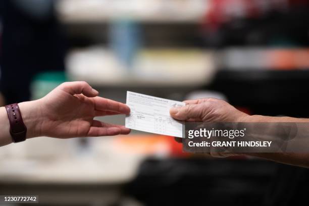 Patient receives a card showing when they received their first dose of the Pfizer Covid-19 vaccine at the Amazon Meeting Center in downtown Seattle,...