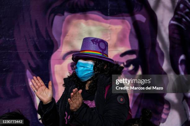 Woman clapping hands next to a feminist mural named 'Union makes force', during a protest against the removal of the mural proposed by far-right...