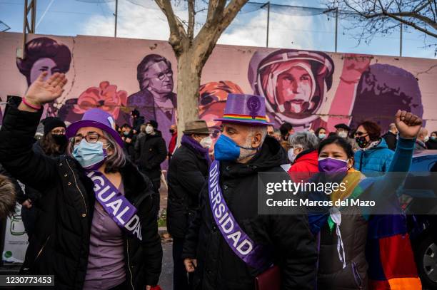 Protesters raise hands next to a feminist mural named 'Union makes force', during a protest against the removal of the mural proposed by far-right...