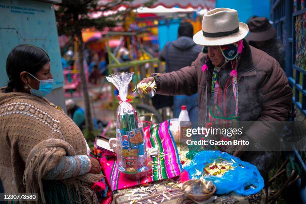 Witch doctor is seen blesses handmade miniatures as part of the traditional Alasitas fair on January 24, 2021 in El Alto, Bolivia. Feria de la...