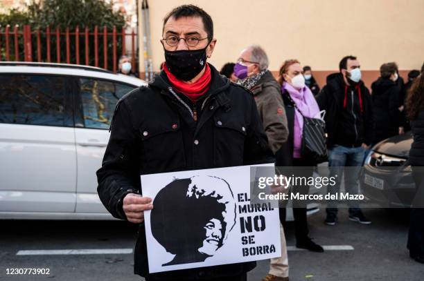 Juan Carlos Monedero, former leading member of Podemos party holding a placard with the picture of Angela Davis and the words 'the mural should not...