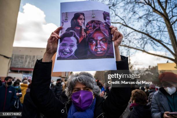 Woman holds a picture of feminist women, during a protest against the removal proposed by far-right party VOX of a feminist mural named 'Union makes...