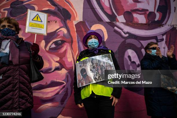 Women with placards next to a feminist mural named 'Union makes force', during a protest against the removal of the mural proposed by far-right party...