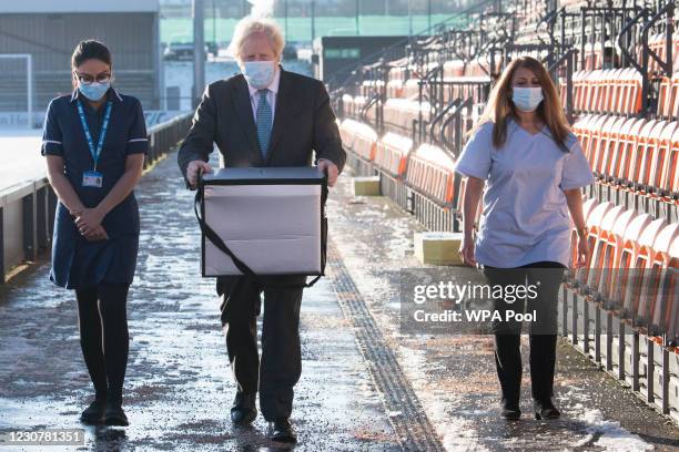 British Prime Minister Boris Johnson carries doses of the Oxford/AstraZeneca coronavirus vaccine for mobile distribution at Barnet FC's ground, The...