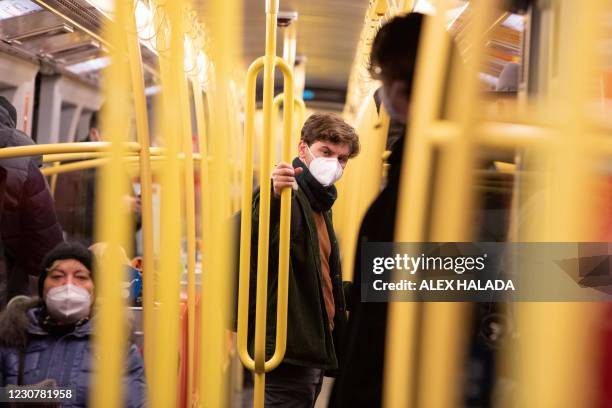 Commuter wears an FFP2 protective face mask on a public transport underground train in Vienna on January 25 during the ongoing novel coronavirus...