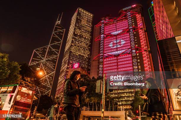 Pedestrians pass the illuminated HSBC Holdings Plc headquarters at night in Hong Kong, China, on Monday, Jan. 25, 2021. HSBC's Chief Executive...