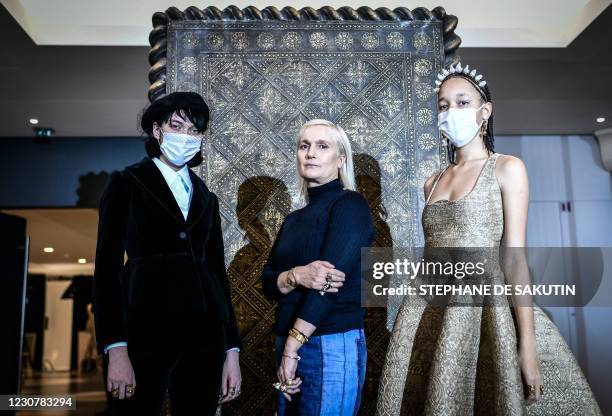 Christian Dior's Italian fashion designer Maria Grazia Chiuri poses with models wearing her creations during a fitting session at Christian Dior's...