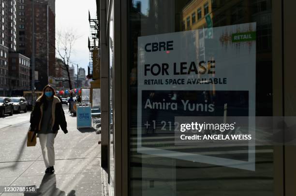 Woman walks past a 'for lease' sign in the midtown area of Manhattan on January 25, 2021 in New York City.