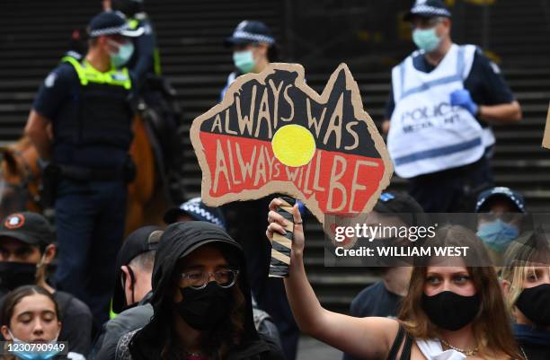 Woman holds up a placard as thousands of people attend an Australia Day protest in Melbourne in January 26, 2021.