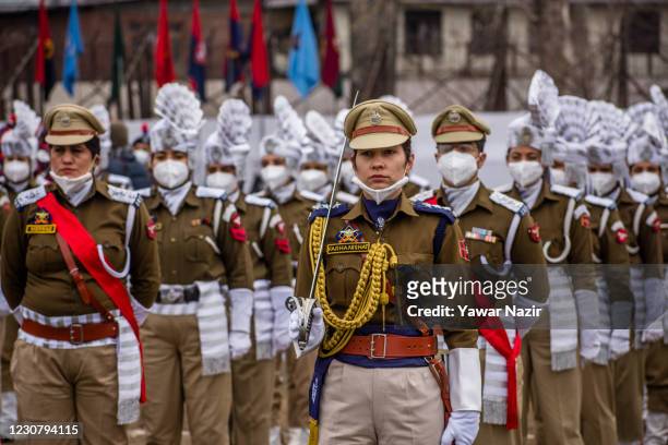 Contingent of Indian women police wearing protective face mask stand in formation before their parade at the Sher- i- Kashmir stadium where the...
