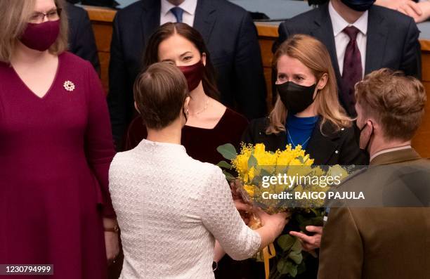 Estonia's President Kersti Kaljulaid gives a bouquet of flowers to the leader of Estonia's Reform Party and new Prime Minister Kaja Kallas after she...