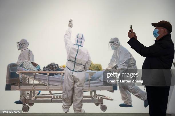 Chinese man wears a protective mask as he visits an exhibition on the city's fight against the coronavirus in Wuhan on January 26, 2021 in Wuhan,...