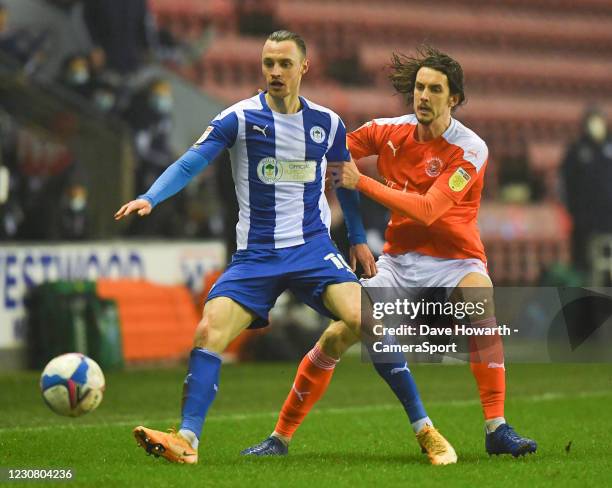 Blackpool's Jordan Williams battles with Wigan Athletic's Will Keane during the Sky Bet League One match between Wigan Athletic and Blackpool at DW...