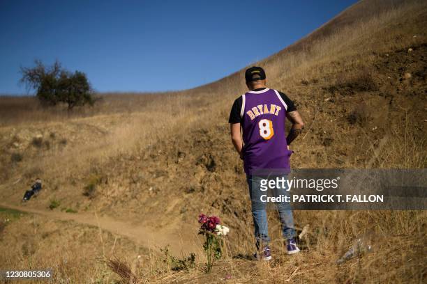 Anthony Calderon leaves flowers to pay his respects at a makeshift memorial on January 26, 2021 in Calabasas, California, at the hillside site of a...
