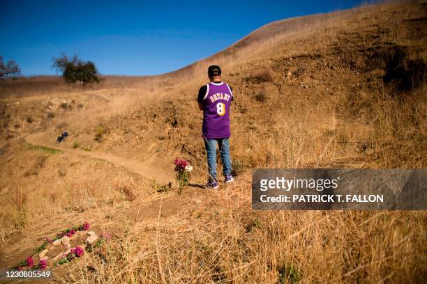 Anthony Calderon leaves flowers to pay his respects at a makeshift memorial on January 26, 2021 in Calabasas, California, at the hillside site of a...