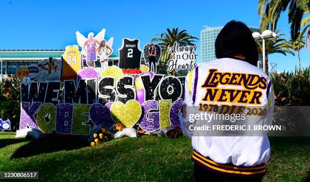 Bree Rodriguez wears a jacket with words "Legends Never Die" as she visits a makeshift memorial near Staples Center in Los Angeles, California on...