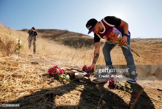Anthony Calderon from West Hills brought flowers and arranged rocks in a figure 8 on the mountainside in Calabasas where a helicopter crashed one...