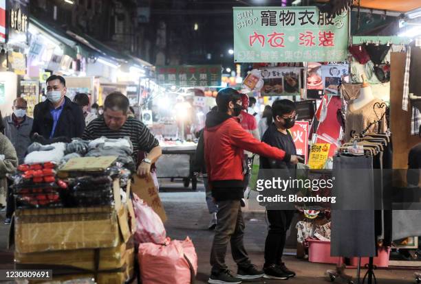 Customers wearing protective masks look at clothing at a stall at the Linjiang night market in Taipei, Taiwan, on Tuesday, Jan. 26, 2021. Taiwan is...