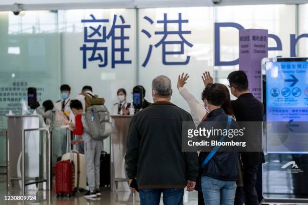 People wave in the departures hall at the Hong Kong International Airport in Hong Kong, China, on Tuesday, Jan. 26, 2021. Hong Kong no longer has the...