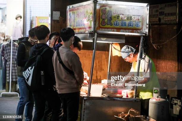 Customers stand in front of a skewer stall at the Linjiang night market in Taipei, Taiwan, on Tuesday, Jan. 26, 2021. Taiwan is scheduled to release...