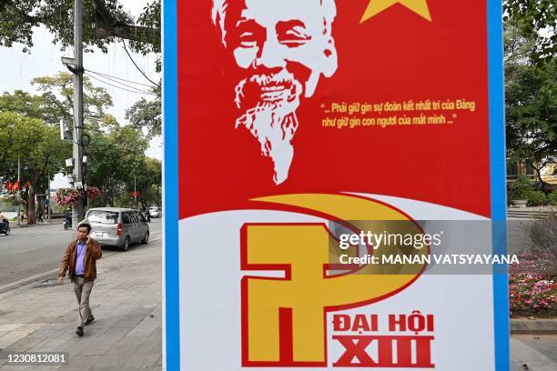 Man walks past a billboard for the ongoing Communist Party of Vietnam's 13th National Congress along a street in Hanoi on January 27, 2021.