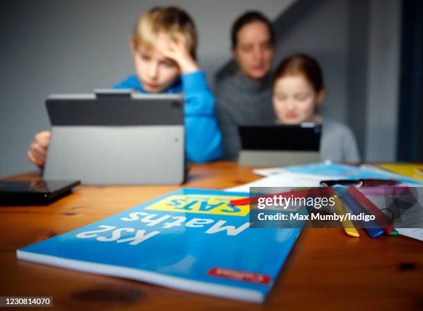 Year old Oscar Mumby and 8 year old Harriet Mumby are assisted with their online schoolwork by their mother Jo Mumby as homeschooling continues due...