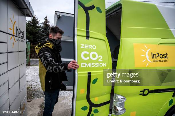 Worker prepares to unload parcels from an electric van beside InPost SA postal lockers in Ozarow, Poland, on Wednesday, Jan. 27, 2021. InPost soared...
