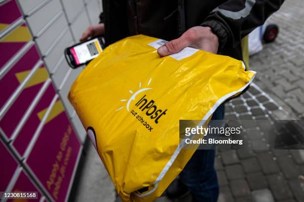 Worker delivers a parcel to an InPost SA postal locker in Warsaw, Poland, on Wednesday, Jan. 27, 2021. InPost soared in Amsterdam trading after its...