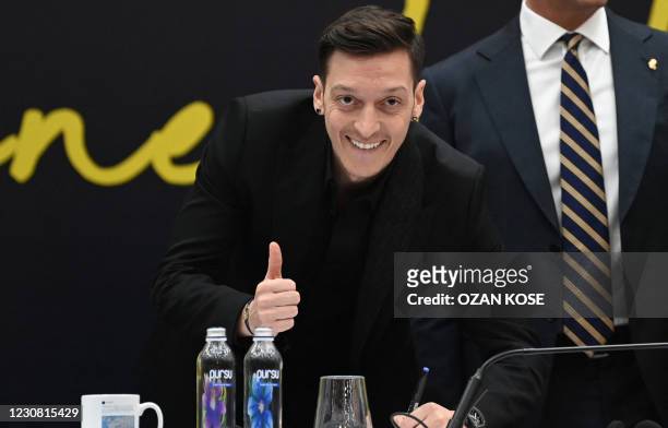 German midfielder Mesut Ozil poses as he signs his new three-and-a-half year contract with Turkish football club Fenerbahce at the Divan Faruk ilgaz...