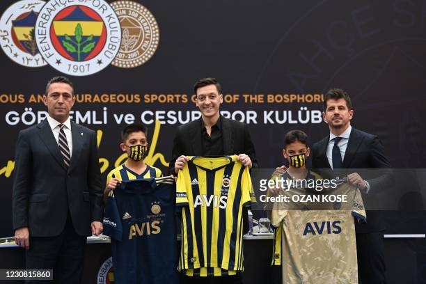 German midfielder Mesut Ozil holds his new jersey as he poses with Fenerbahce's president Ali Koc and sport director Emre Belezoglu , during a press...