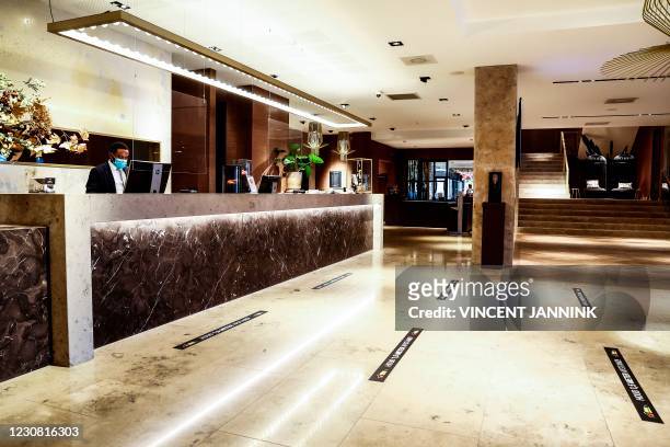 Picture shows the empty lobby in the Van der Valk hotel in Enschede on January 27 amid the Covid-19 pandemic. - The hotel company fears that...