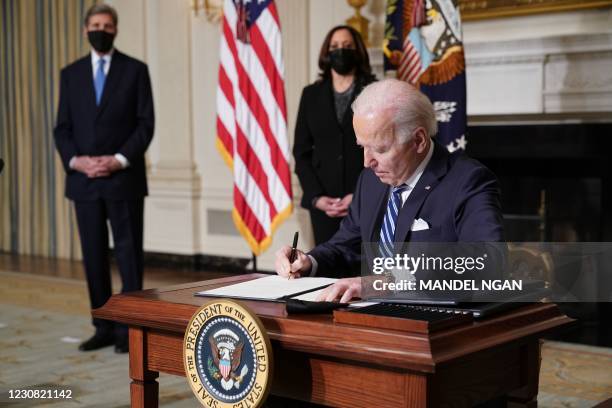 Vice President Kamala Harris and Special Presidential Envoy for Climate John Kerry watch as US President Joe Biden signs executive orders after...