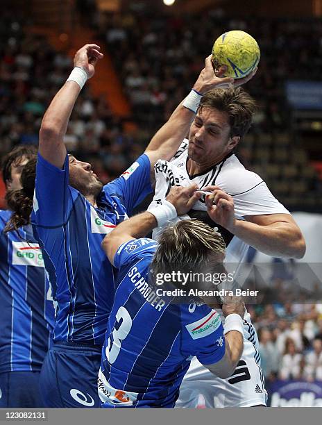 Marcus Ahlm of Kiel is challenged by Bertrand Gille and Stefan Schroeder during the Handball Supercup match between HSV Hamburg and THW Kiel on...
