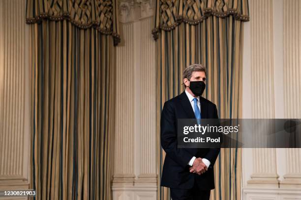 Special Presidential Envoy for Climate John Kerry listens as U.S. President Joe Biden speaks about climate change issues in the State Dining Room of...