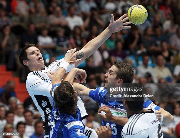 Kim Andersson of Kiel is challenged by Torsten Jansen and Guillaume Gille of Hamburg during the Handball Supercup match between HSV Hamburg and THW...