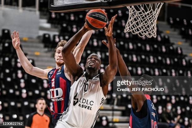 Lyon-Villeurbanne's French player Moustapha Fall fights for the ball with Baskonia's Estonian player Sander Raieste and Baskonia's Senegalese player...