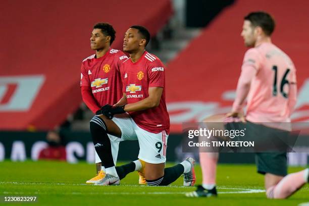 Manchester United's English striker Marcus Rashford and Manchester United's French striker Anthony Martial take a knee against racism during the...