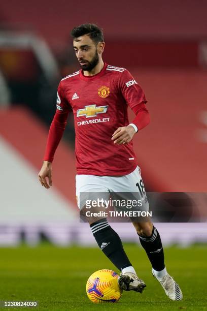 Manchester United's Portuguese midfielder Bruno Fernandes runs with the ball during the English Premier League football match between Manchester...