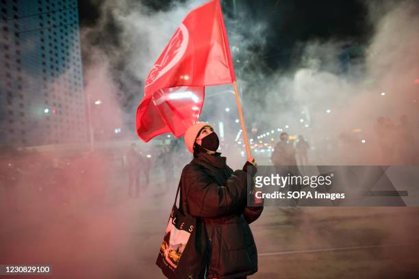 Protester waves a flag during the demonstration. Hundreds took the streets in Warsaw to take part in a protest organized by the Women's Strike...
