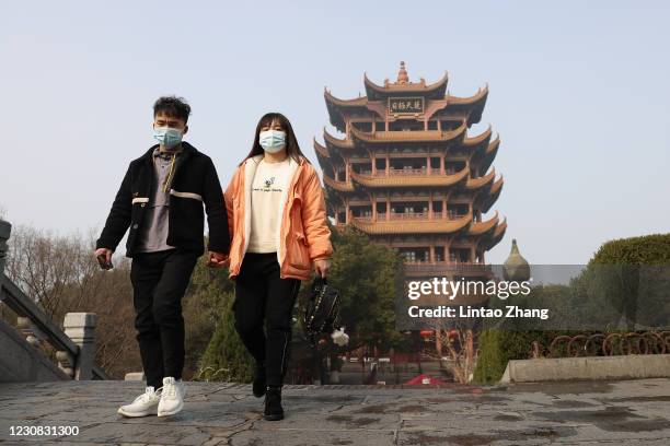 People wearing face masks visit the Yellow Crane Tower on January 28, 2021 in Wuhan, China. In order to curb the spread of the new crown pneumonia...