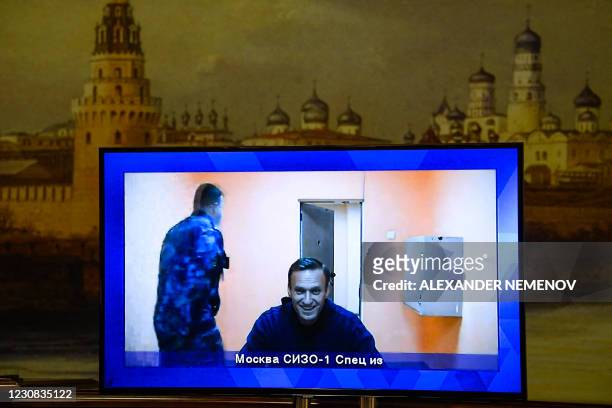Opposition leader Alexei Navalny appears on a screen set up at a hall of the Moscow Regional Court via a video link from Moscow's penal detention...