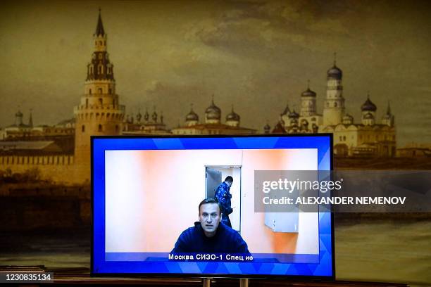 Opposition leader Alexei Navalny appears on a screen set up at a hall of the Moscow Regional Court via a video link from Moscow's penal detention...