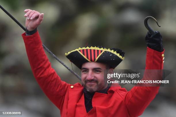 French skipper Damien Seguin, disguised as a pirate, celebrates after crossing the finish line of the Vendee Globe round-the-world solo sailing race,...