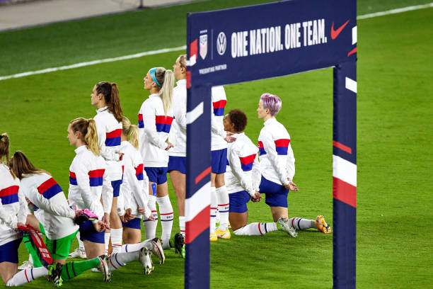 Several United States players including United States forward Megan Rapinoe and United States defender Crystal Dunn are seen taking a kneel during...