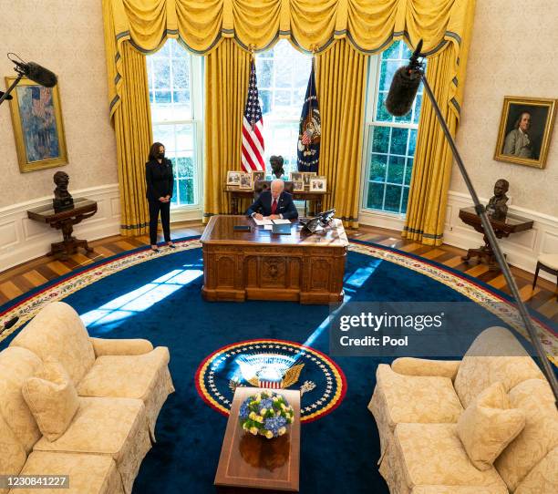 Vice President Kamala Harris looks on as U.S. President Joe Biden signs executive actions in the Oval Office of the White House on January 28, 2021...