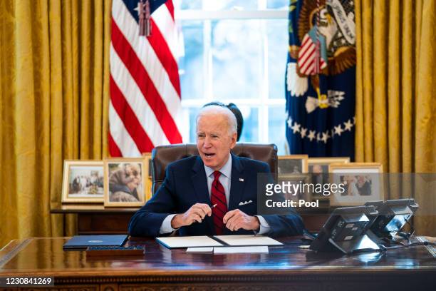 President Joe Biden signs executive actions in the Oval Office of the White House on January 28, 2021 in Washington, DC. President Biden signed a...