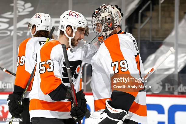 Carter Hart of the Philadelphia Flyers is congratulated by Shayne Gostisbehere after the teams 3-1 victory against the New Jersey Devils at...