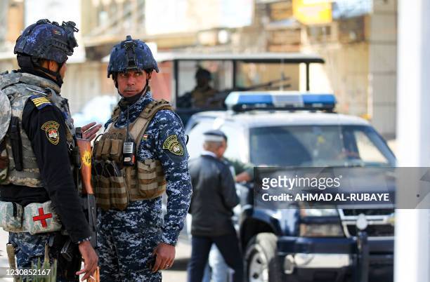 Member of the Iraqi federal police forces stand guard at a checkpoint in a street in the capital Baghdad on January 29 during tightened security...