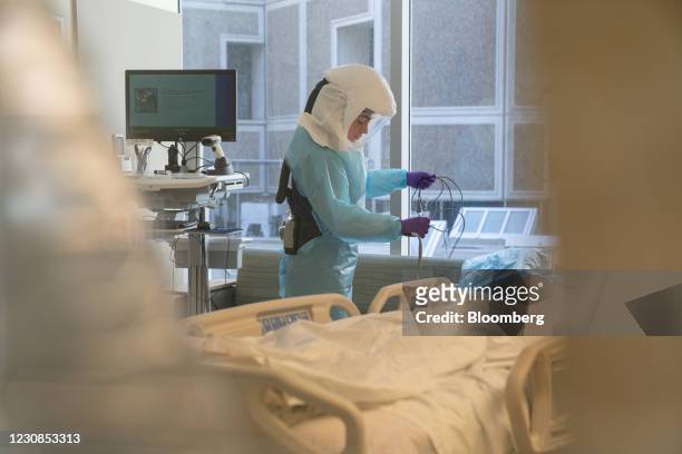 Hospital worker wearing a 3M Co. Powered air purifying respirator hood disinfects a room after a patient departure at the Covid-19 Intensive Care...